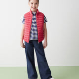 Girl in red sleeveless recycled jacket and navy pants