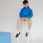 Repose AMS Kids Chino Pants in Sand, shown worn with rolled cuffs. Only the chino pants are for sale.