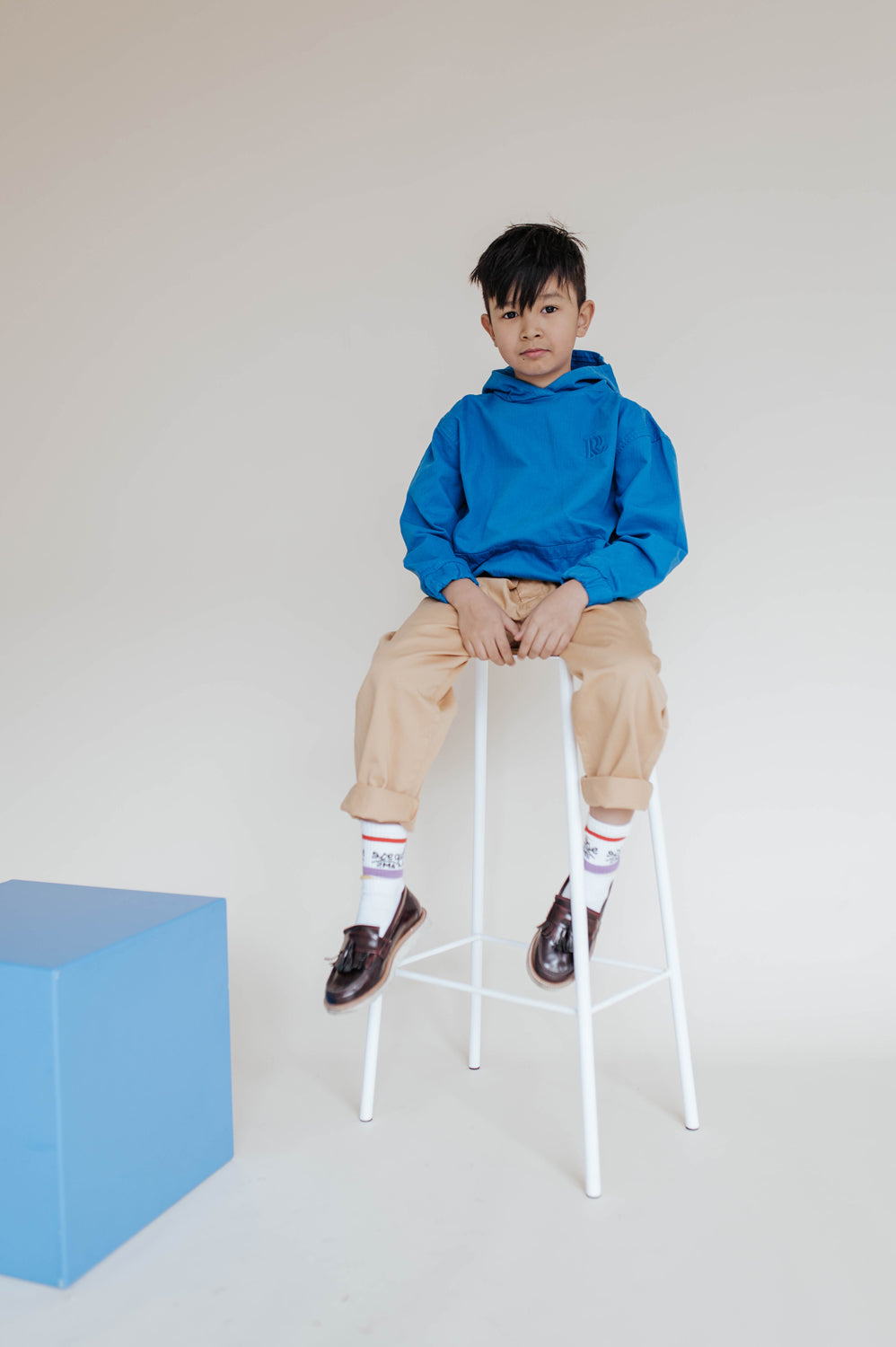 Repose AMS Kids Chino Pants in Sand, shown worn with rolled cuffs. Only the chino pants are for sale.
