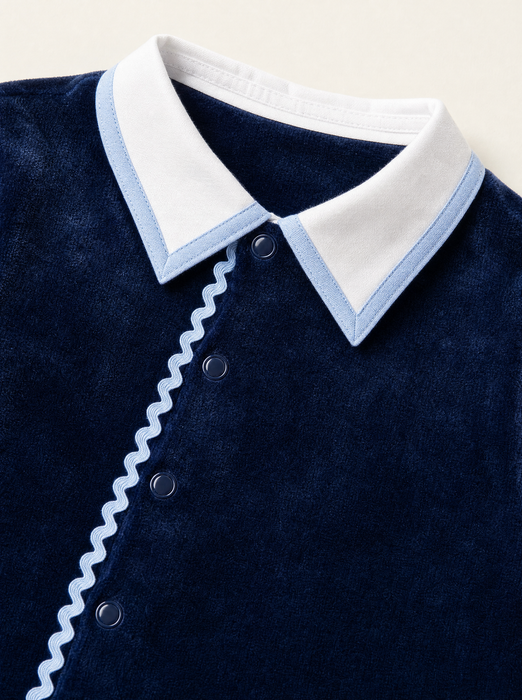 Bebe Sweeny navy velour babygrow, collar with light blue edging and ric-rac trim close-up