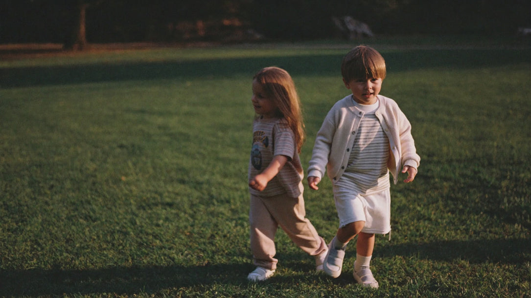 Children walking on grass in summer cotton clothing